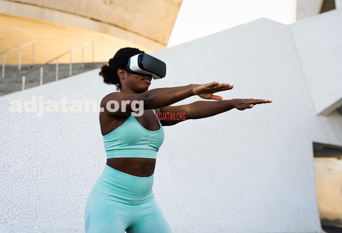 Happy fit African woman using futuristic virtual reality glasses during training session